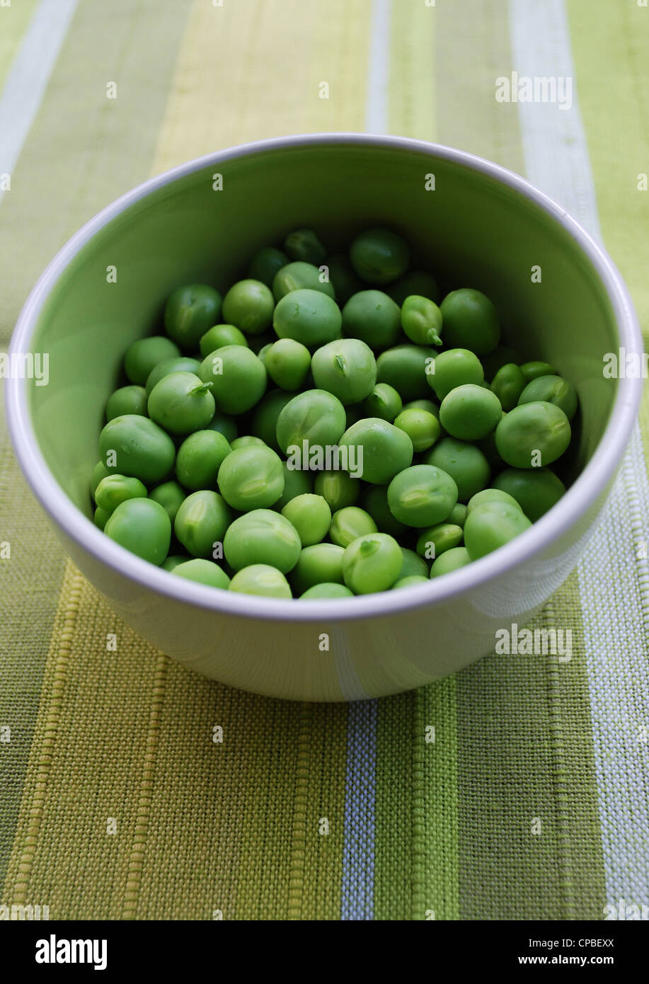 Shelled fresh ripe sweet green peas in a ceramic bowl Stock Photo