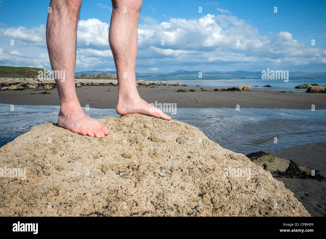 Man Standing Barefoot On Rock On Beach Shoreline Stock Photo Alamy