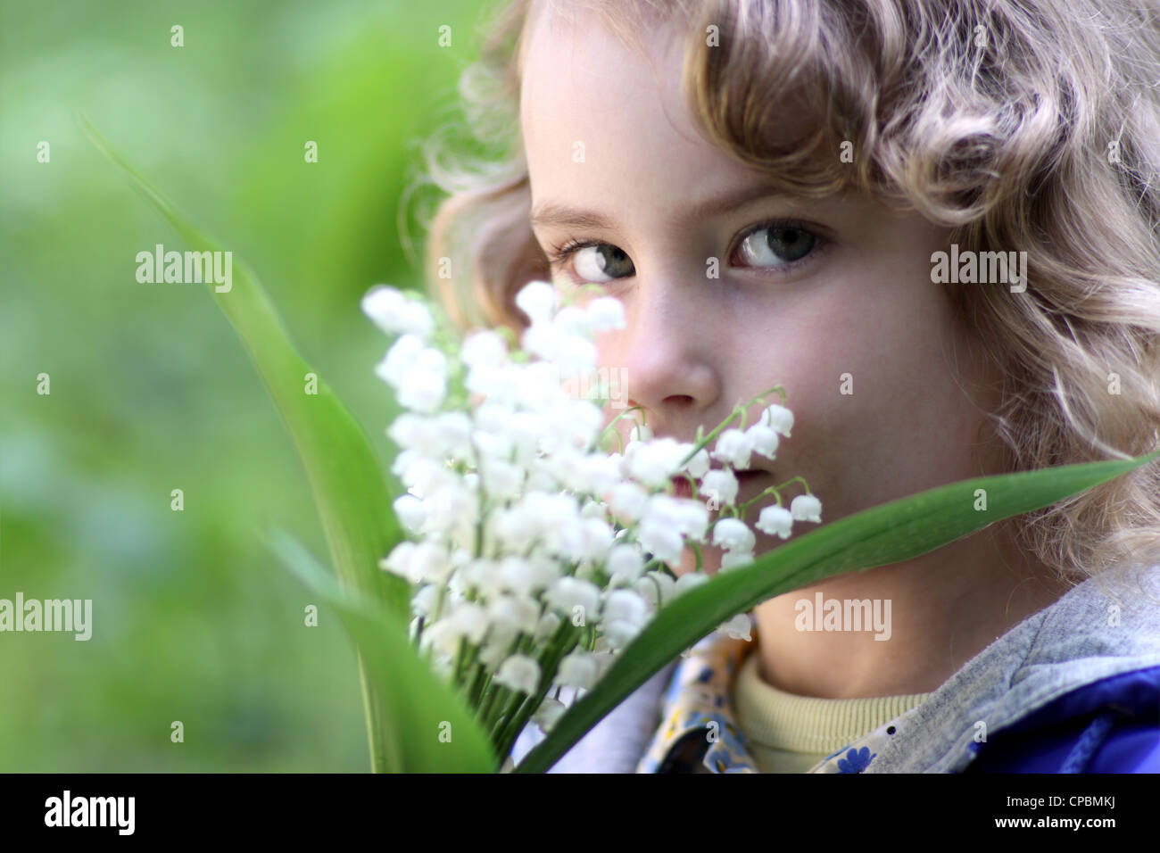 Lovely girl with a bouquet of lily of the valley Stock Photo - Alamy