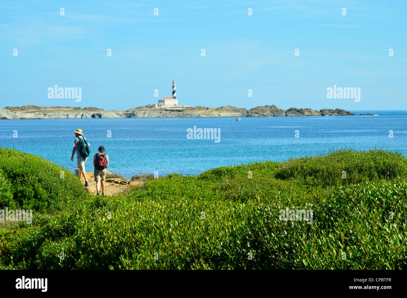 Wakers heading towards the lighthouse at Favàritx on Menorca in the Balearic islands, Spain Stock Photo