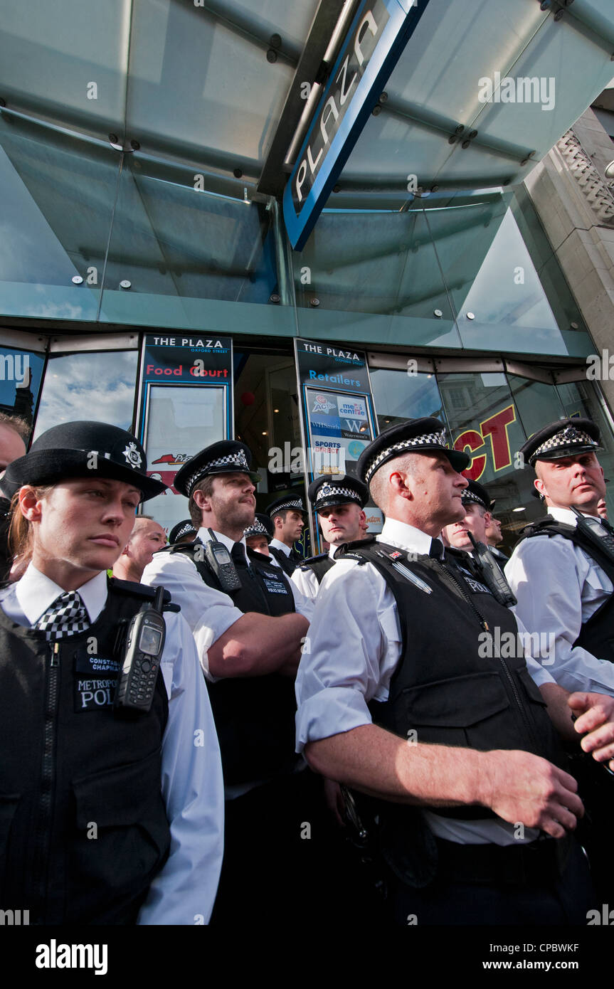 Police guarding shops on Oxford Street against Occupy London protesters and Workfare demonstrators Stock Photo