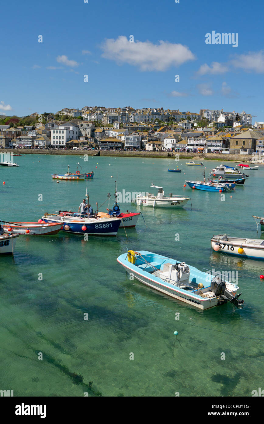 St. Ives habour boats floating on shallow clear sea water. Stock Photo
