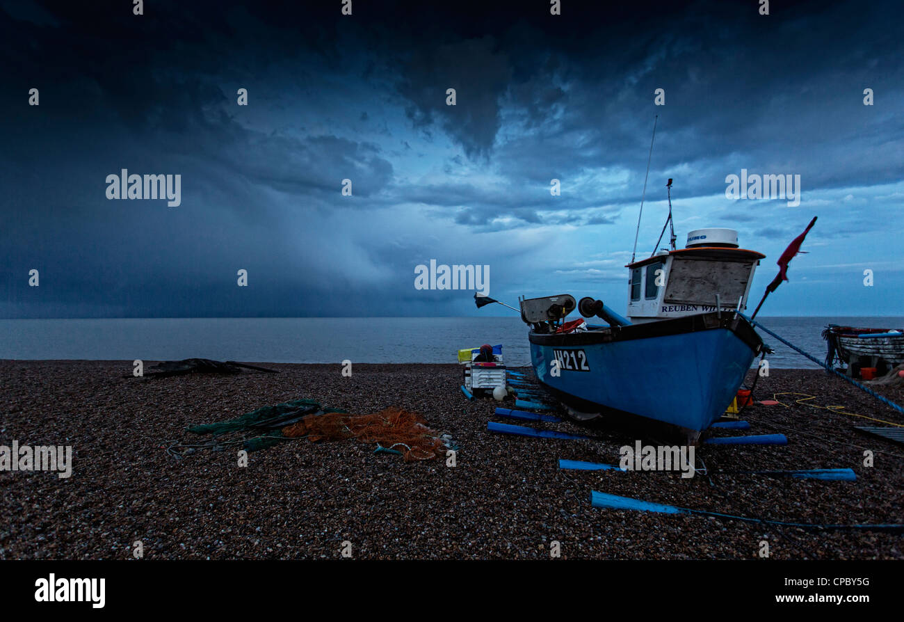 Fishing boat on Aldbrough beach during Stormy Weather. Suffolk Uk Stock Photo