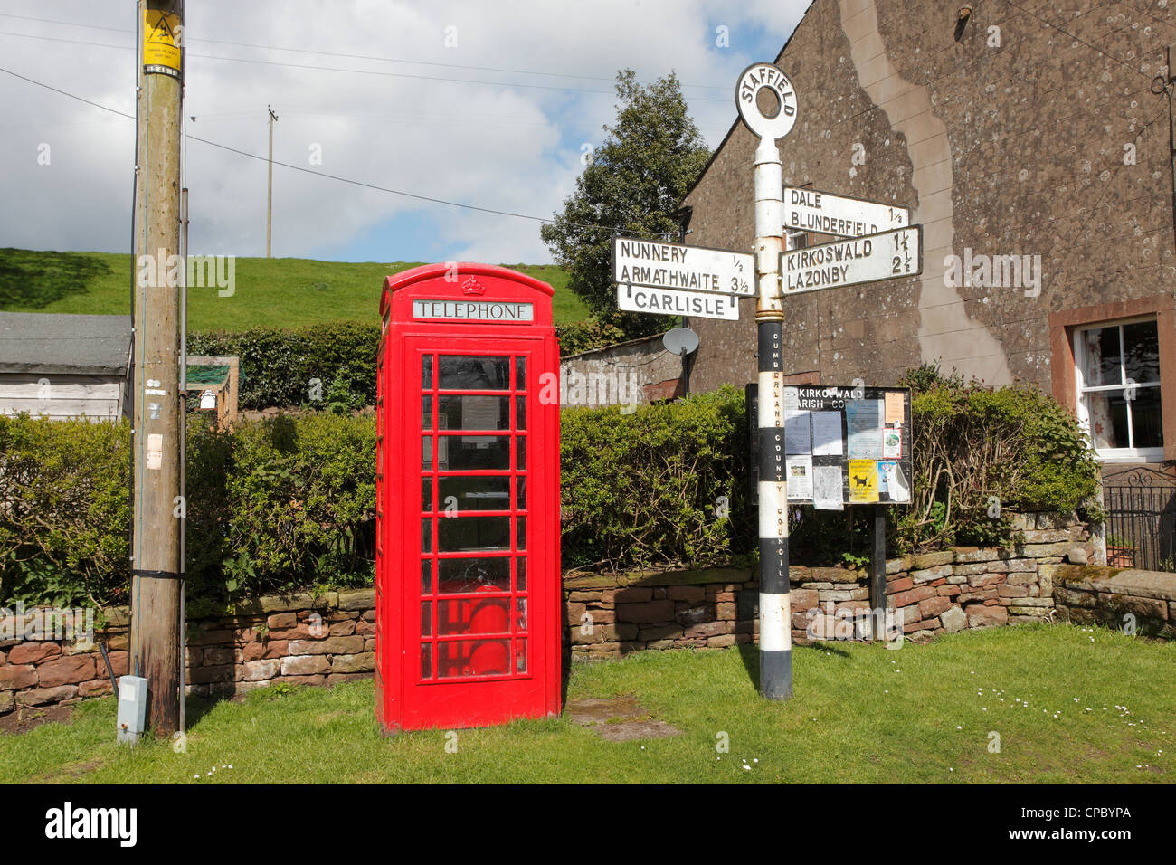 Red telephone box, telegraph pole and sign post in Staffield in the Eden Valley, near Penrith, Cumbria Stock Photo