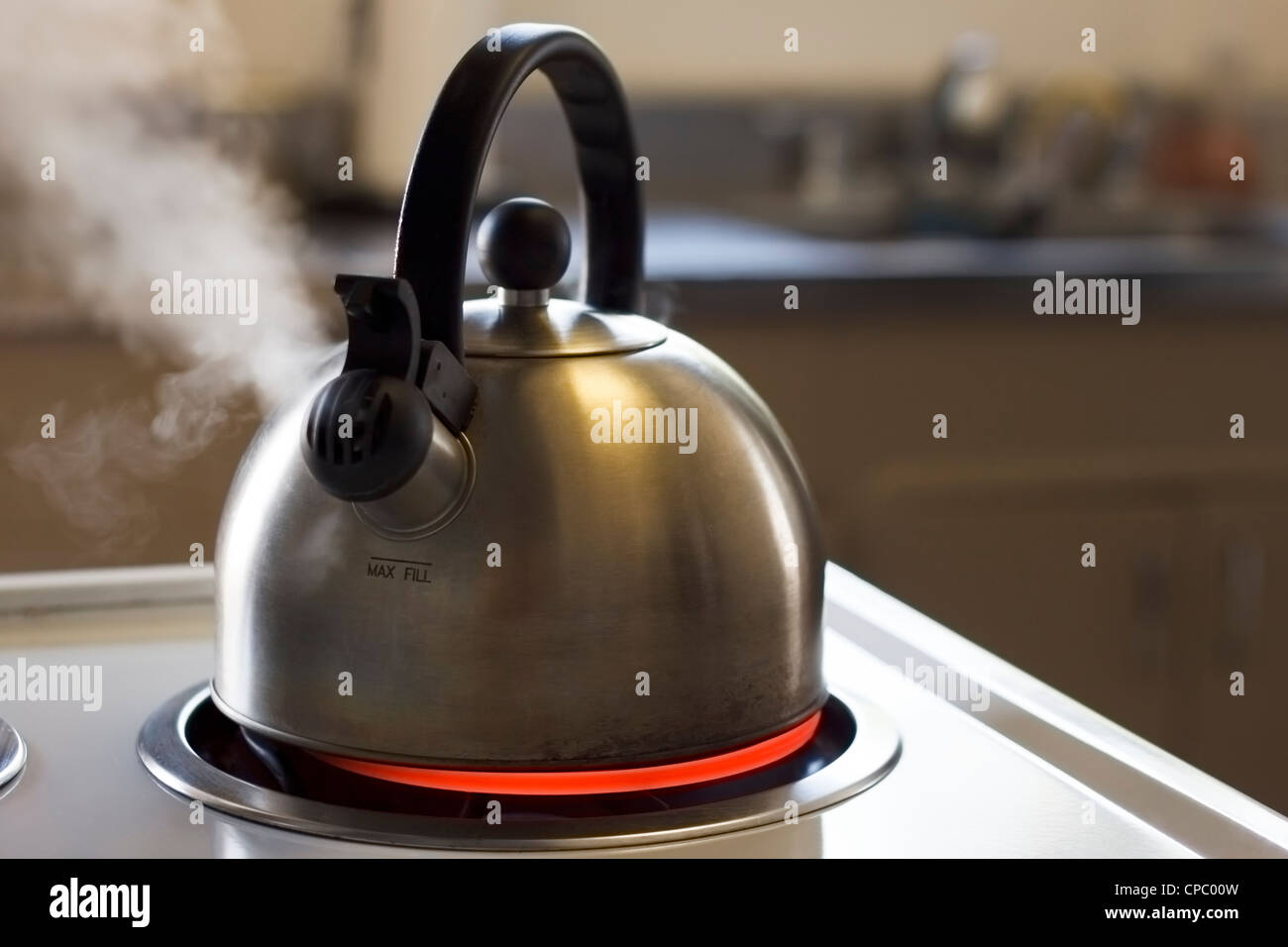 https://c8.alamy.com/comp/CPC00W/stainless-steel-tea-kettle-boiling-with-a-kitchen-in-the-background-CPC00W.jpg