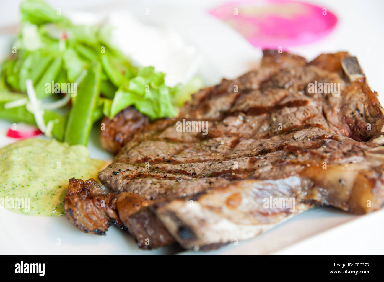 Steak with marks on a white plate with some sallad Stock Photo