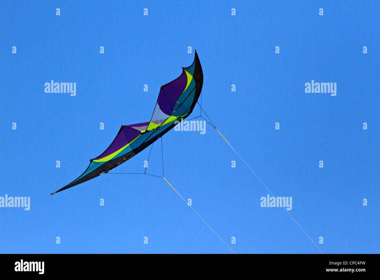 Kite flying against a clear, blue, cloudless sky. Stock Photo