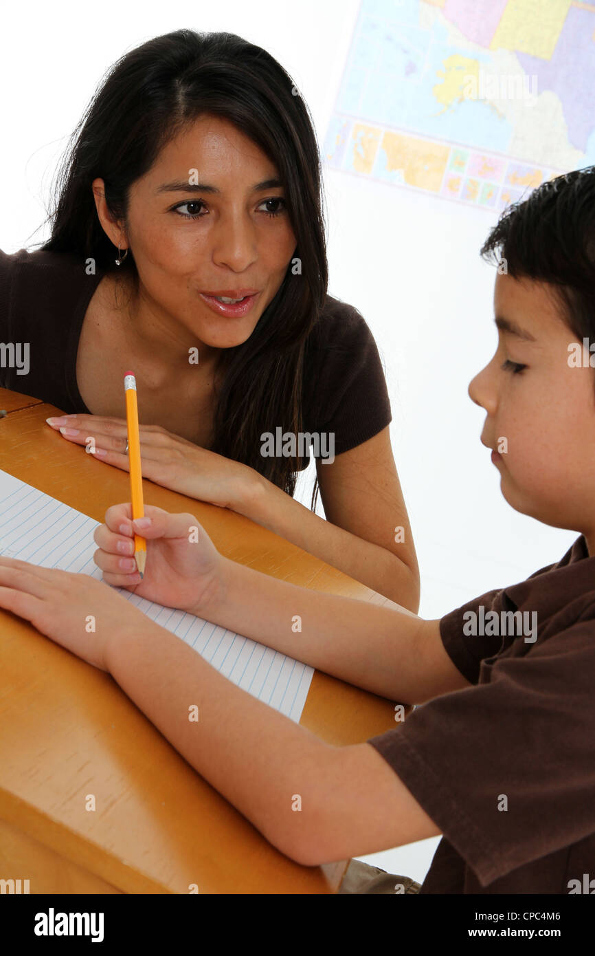 Young Boy Working at Desk with Teacher Stock Photo