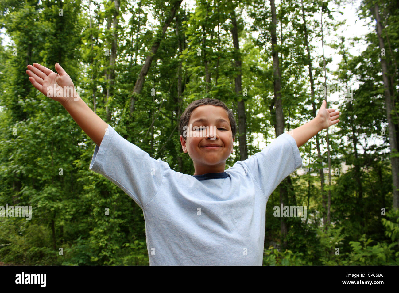 Boy with his arms in the air celebrating Stock Photo - Alamy