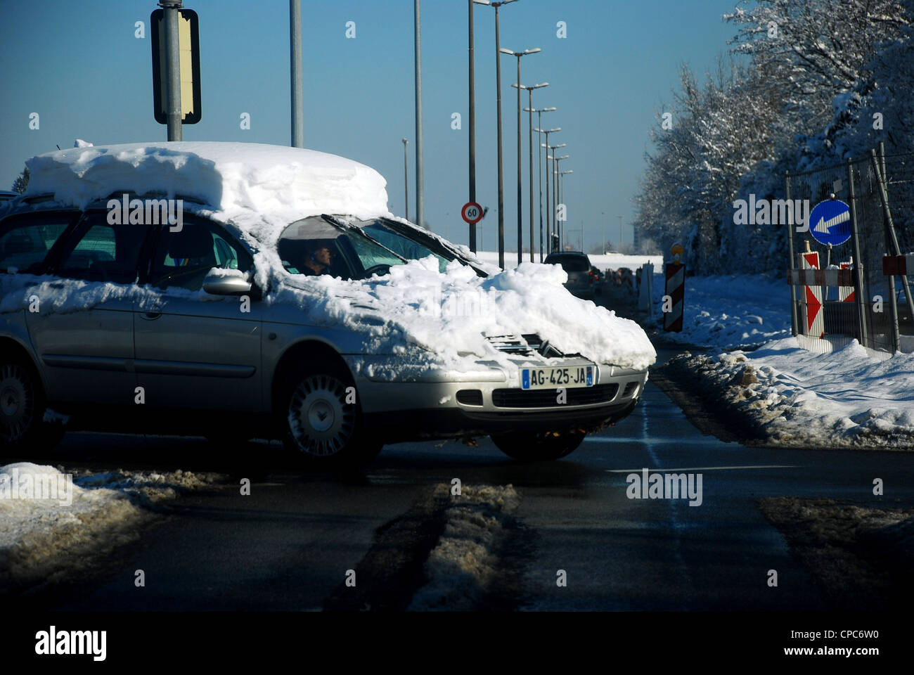 Car covered in snow maneuvering a turn in Switzerland Stock Photo