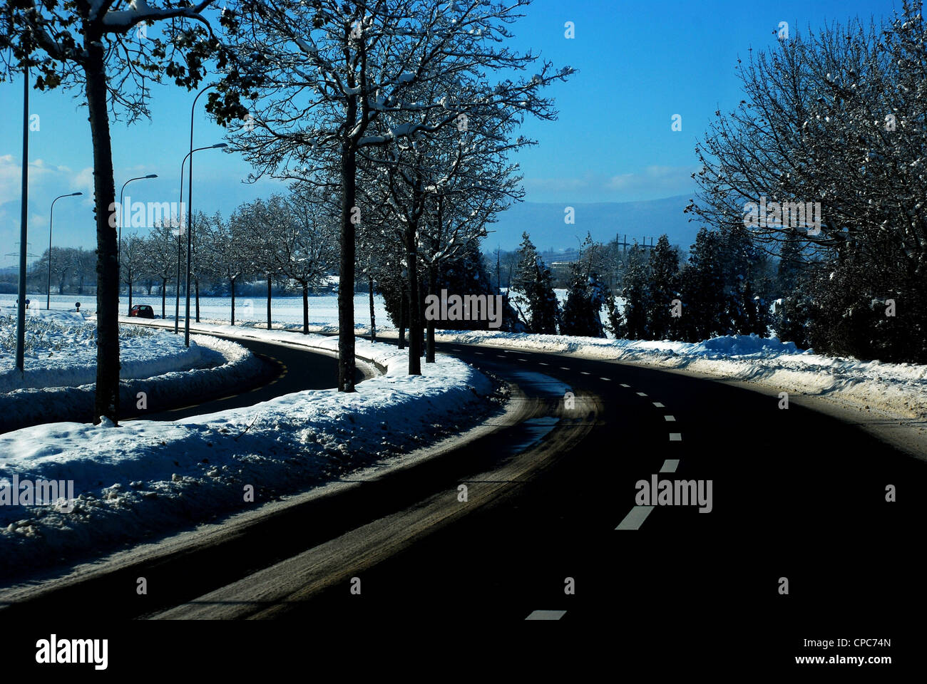 meandering road with snow by the sides Stock Photo