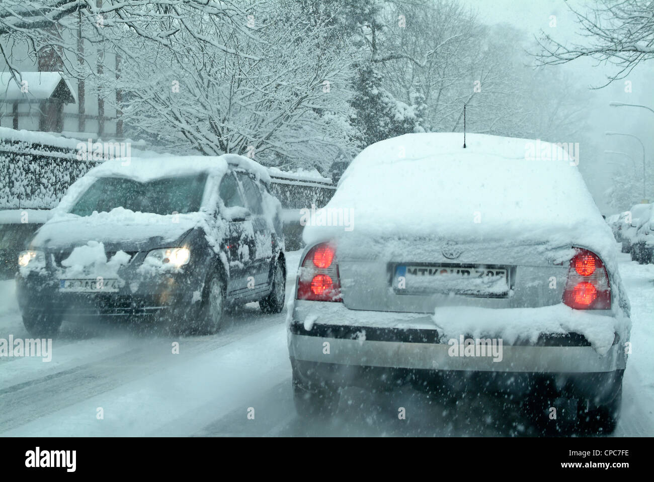 Snow covered cars on a winter road. Stock Photo