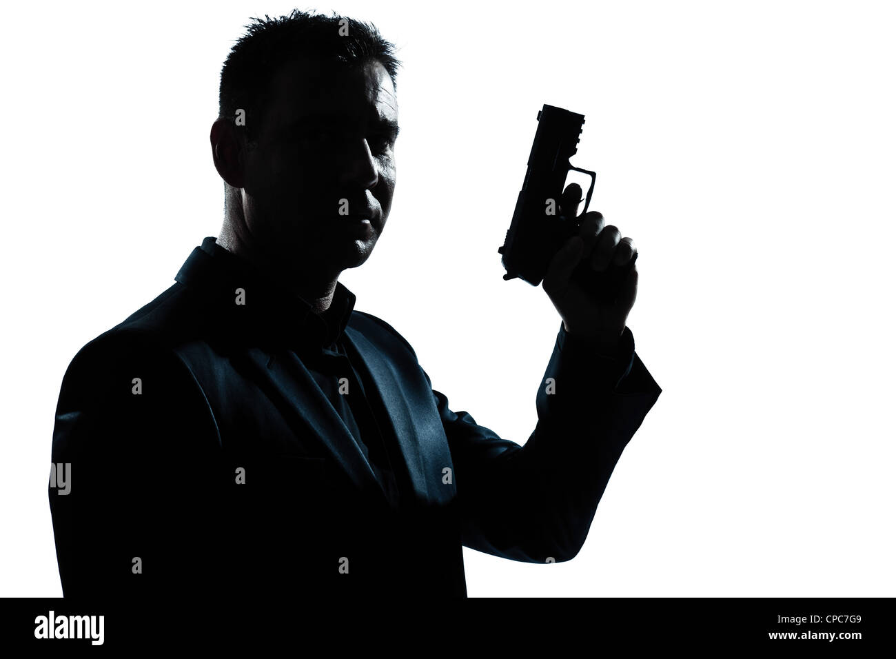 one caucasian spy criminal policeman detective man holding gun portrait silhouette in studio isolated white background Stock Photo