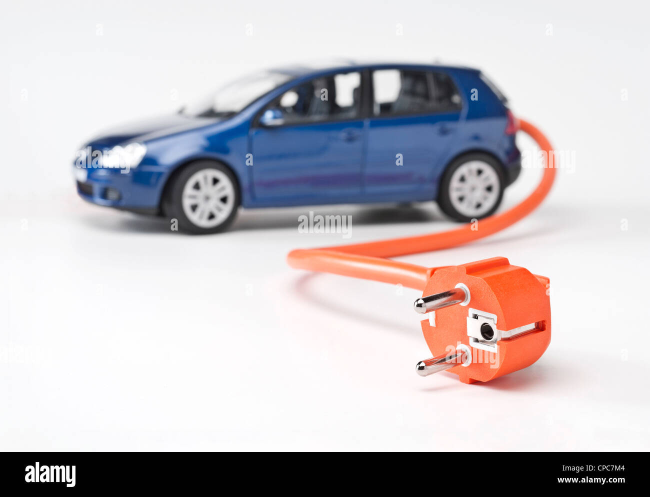 Electric car with an orange power cable. Stock Photo
