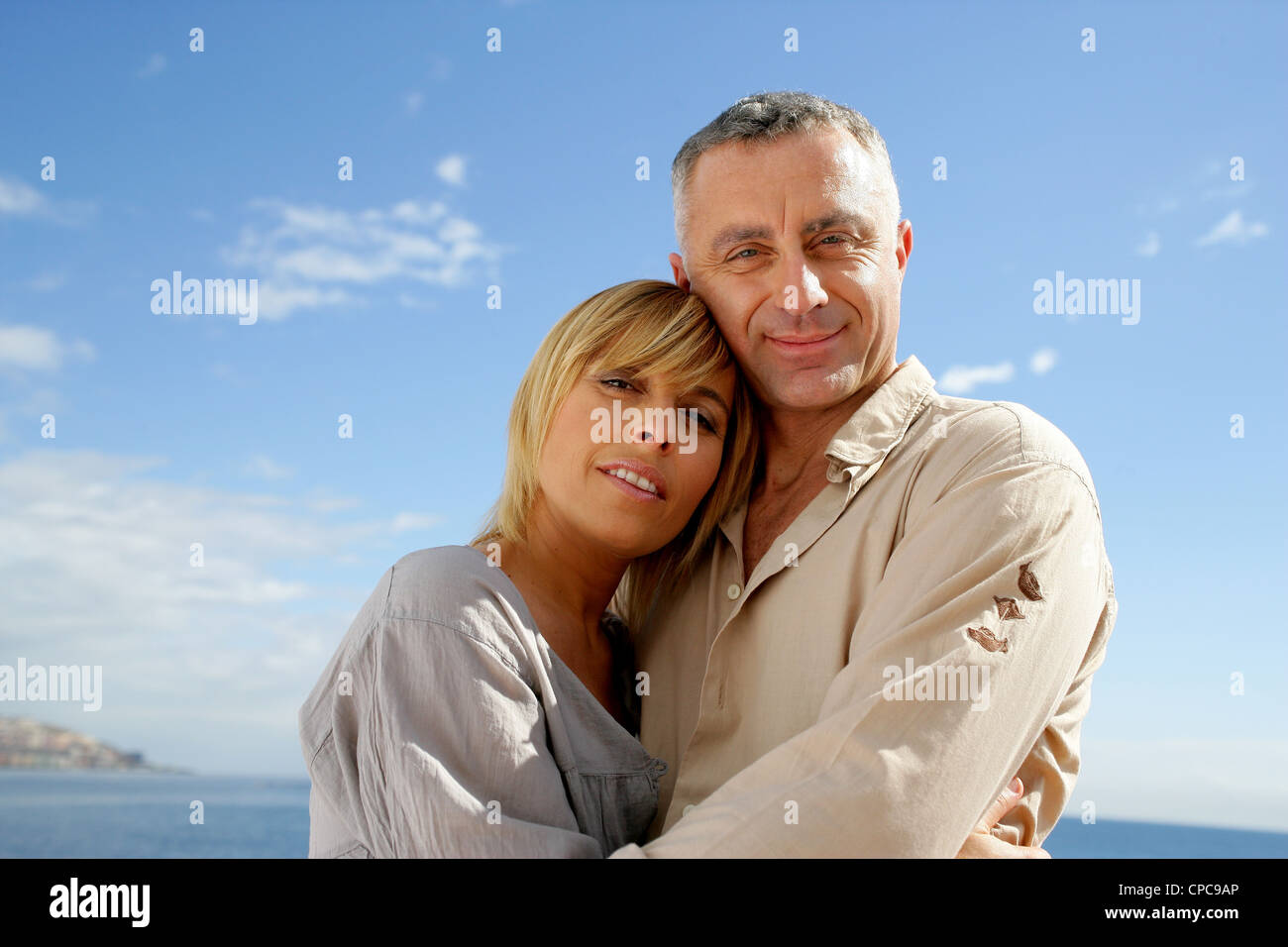 Couple hugging against a blue sky Stock Photo - Alamy