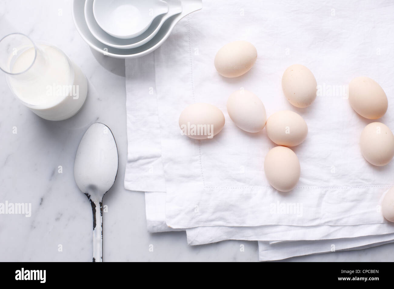 Eggs, milk and spoon on table Stock Photo