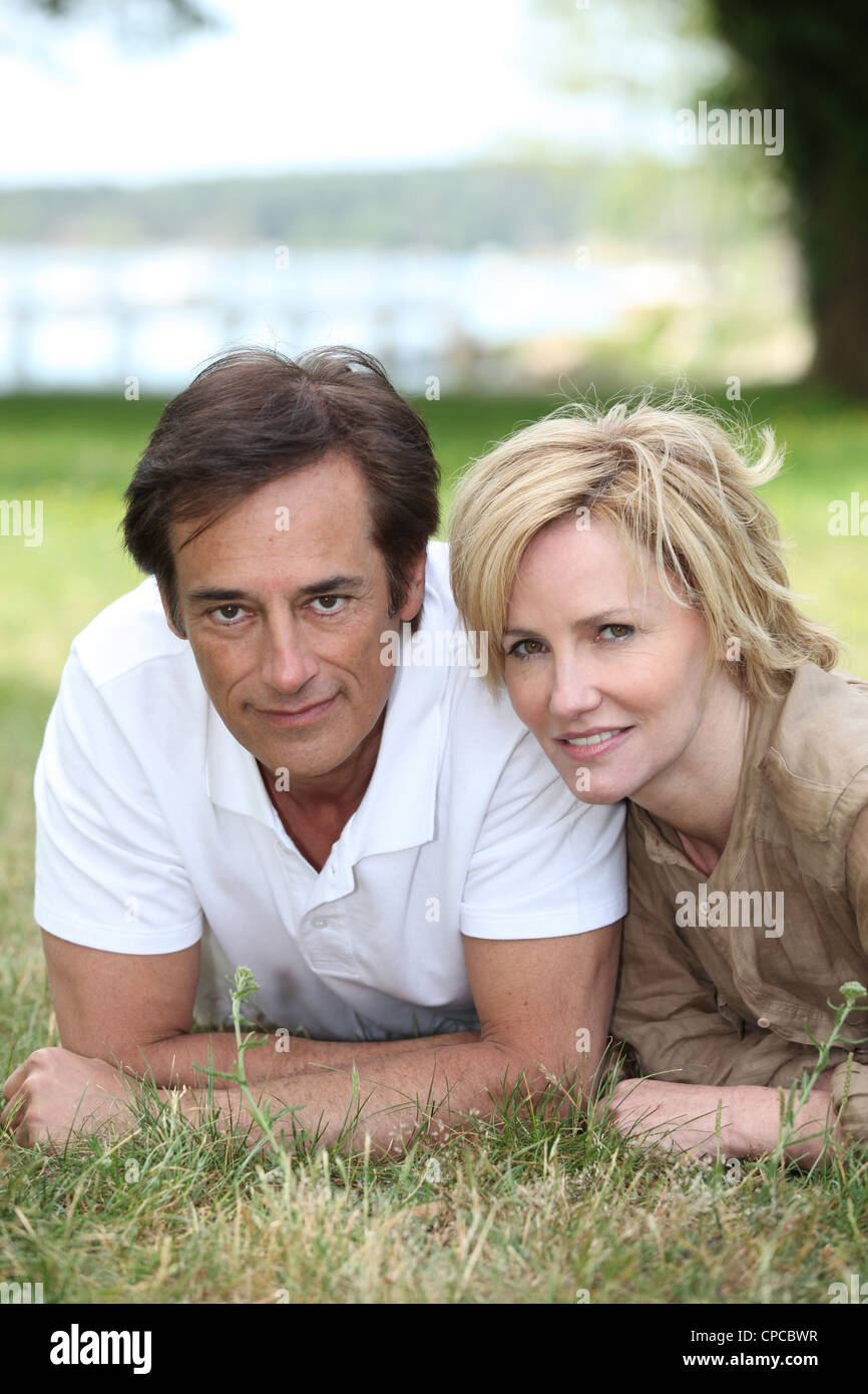 couple lying on the grass Stock Photo - Alamy