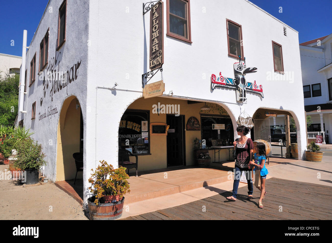 Woman and child stroll by the Palomar Inn which also houses the Curry Vineyards wine tasting room in Temecula, California Stock Photo