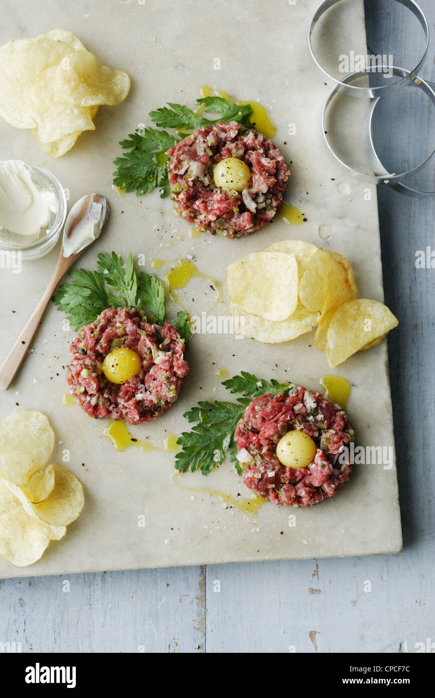 Steak tartar with eggs and chips Stock Photo