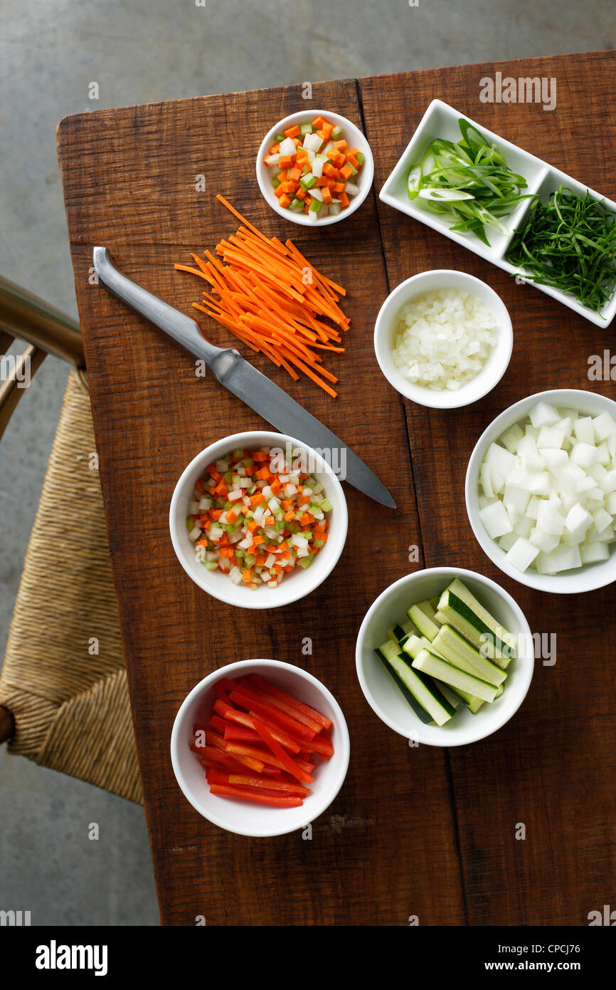 Bowls of chopped vegetables on table Stock Photo