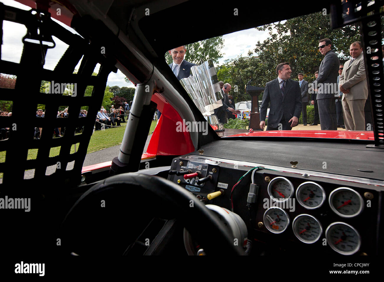 President Barack Obama looks at the NASCAR Sprint Cup Series Championship trophy as he approaches Tony Stewart's car during an event on the South Lawn of the White House April 17, 2012 in Washington, DC. Stock Photo