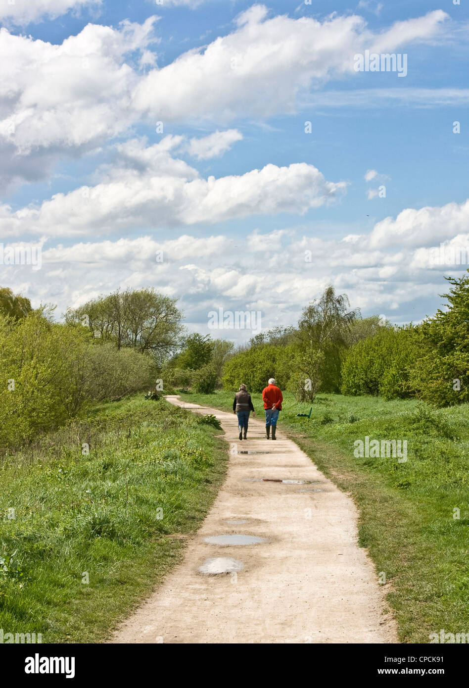 Middle-aged mature adult couple walking together on a country lane footpath England Europe Stock Photo