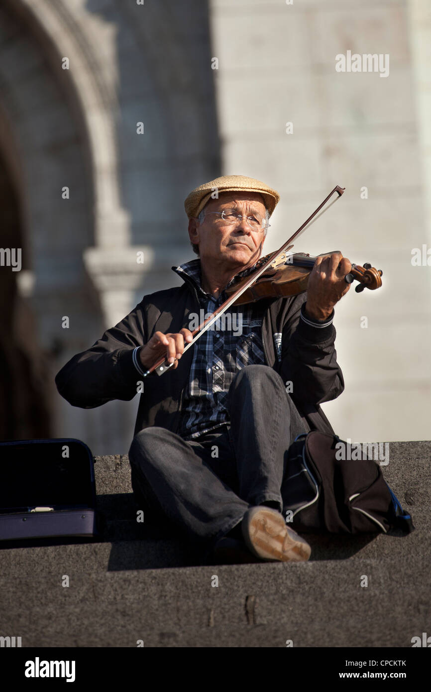 Violinist playing music on the steps of the Sacre-Coeur. Paris, France. Stock Photo