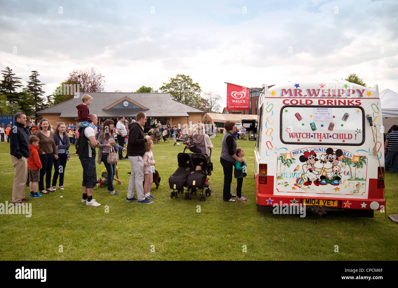 Children and families queue for ice cream from an ice cream van