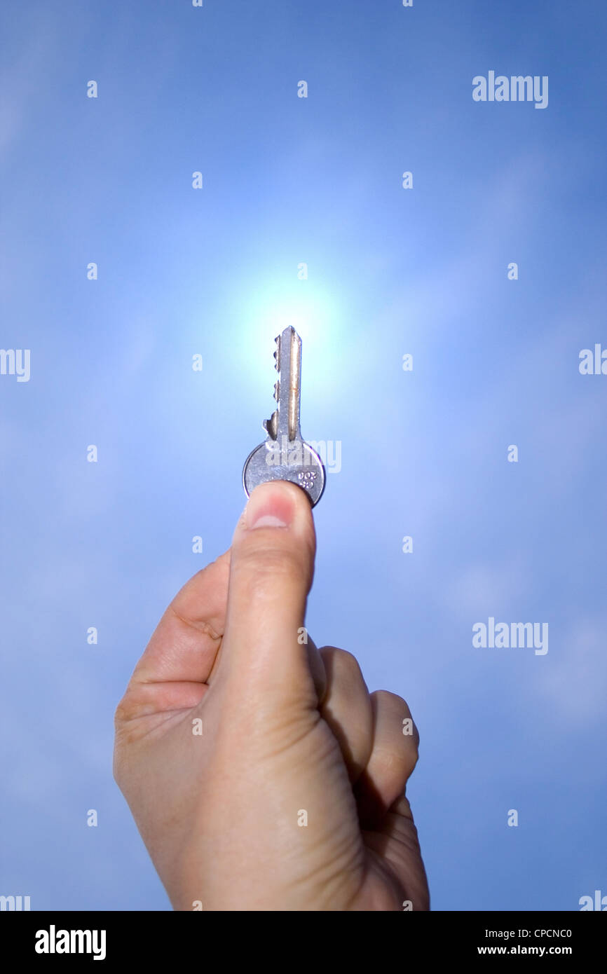 A hand holding a key up in the sky Stock Photo Alamy