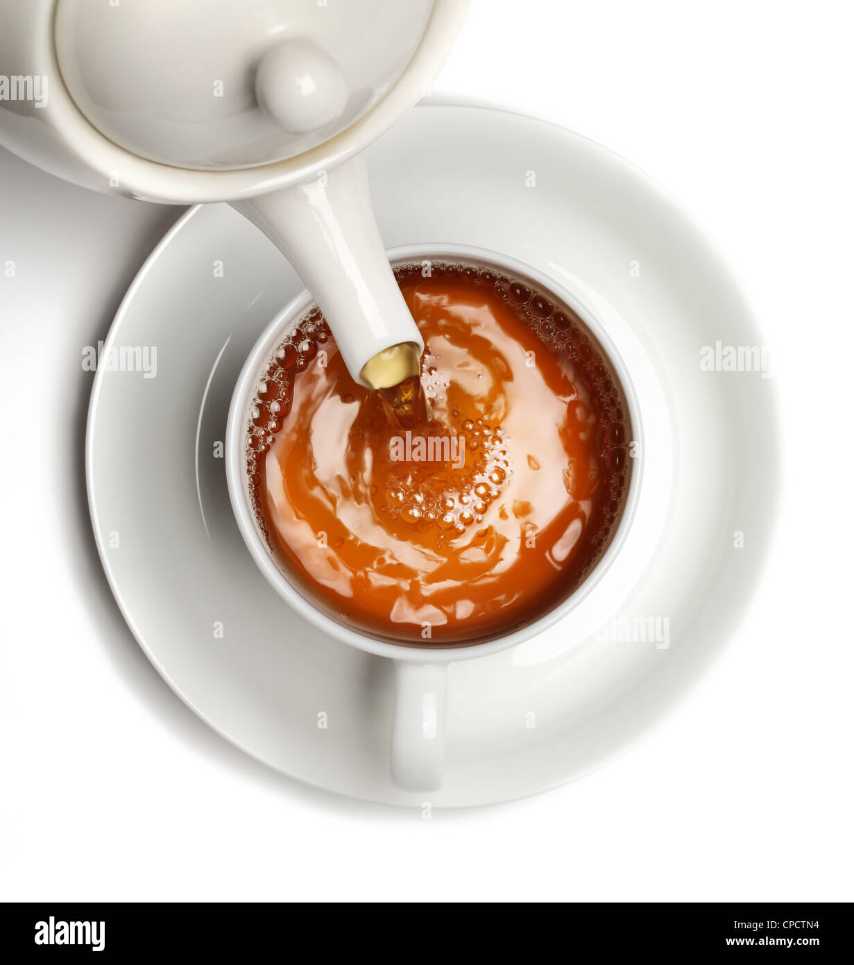 Tea being poured into tea cup,Isolated on white background. Stock Photo