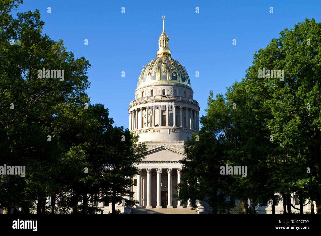West Virginia State Capitol in Charleston, West Virginia, USA surrounded by trees against a blue sky background. Stock Photo