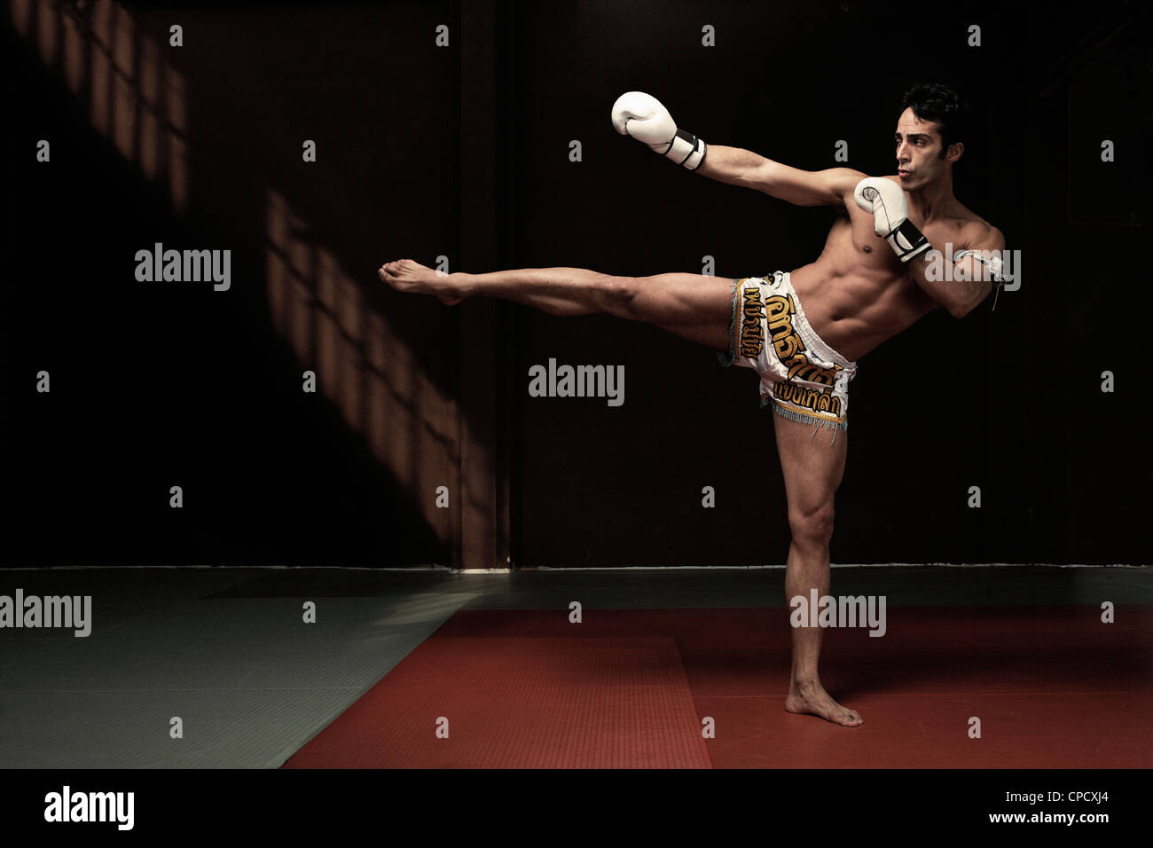Boxer kicking on mat Stock Photo