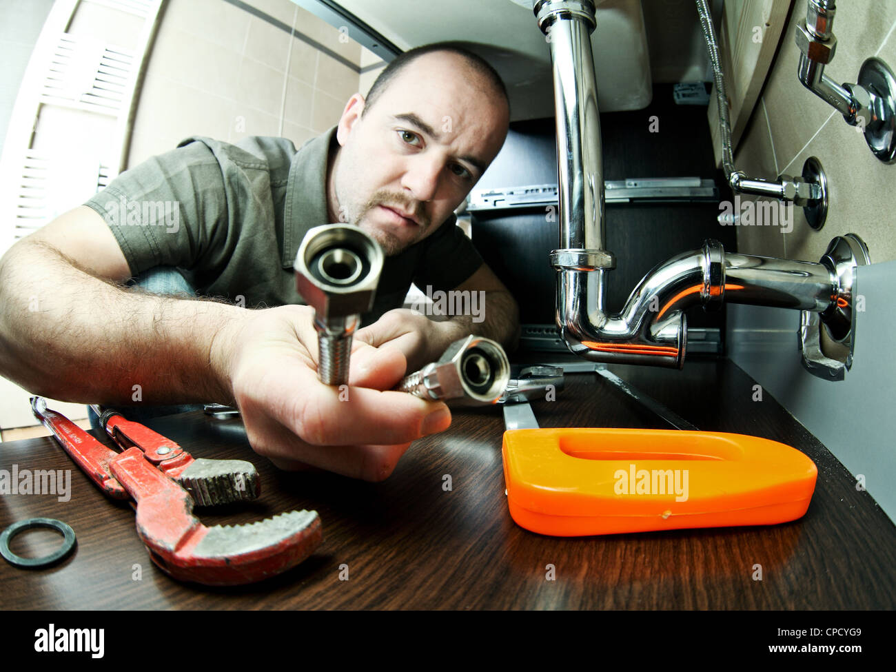 plumber on duty with bath pipes Stock Photo