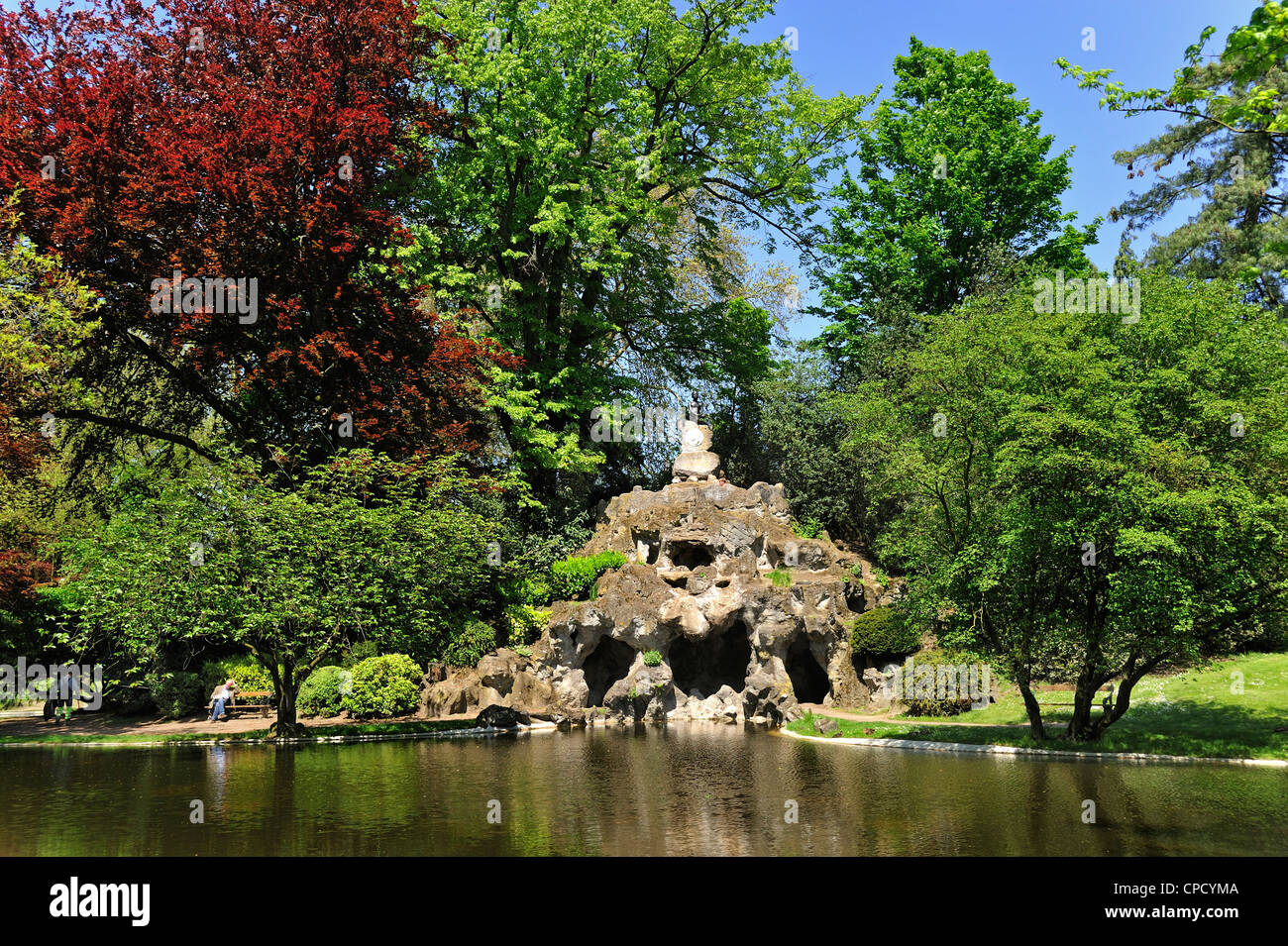 Artificial cave and pond in the Citadel city park / Citadelpark in spring at Ghent, Belgium Stock Photo