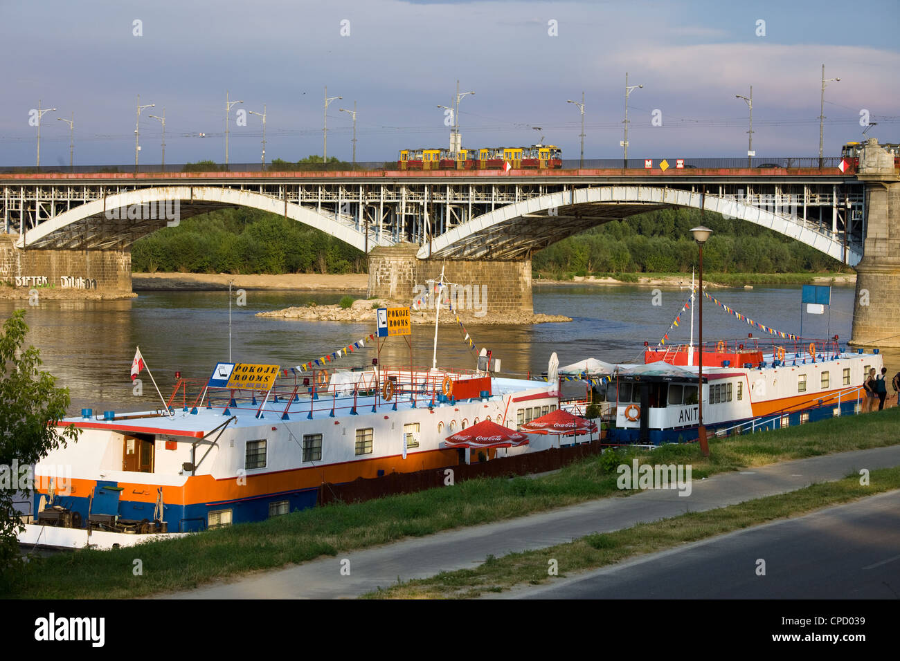 Passenger boats with rooms for rent and restaurant services and Poniatowski Bridge on the Vistula river in Warsaw, Poland. Stock Photo