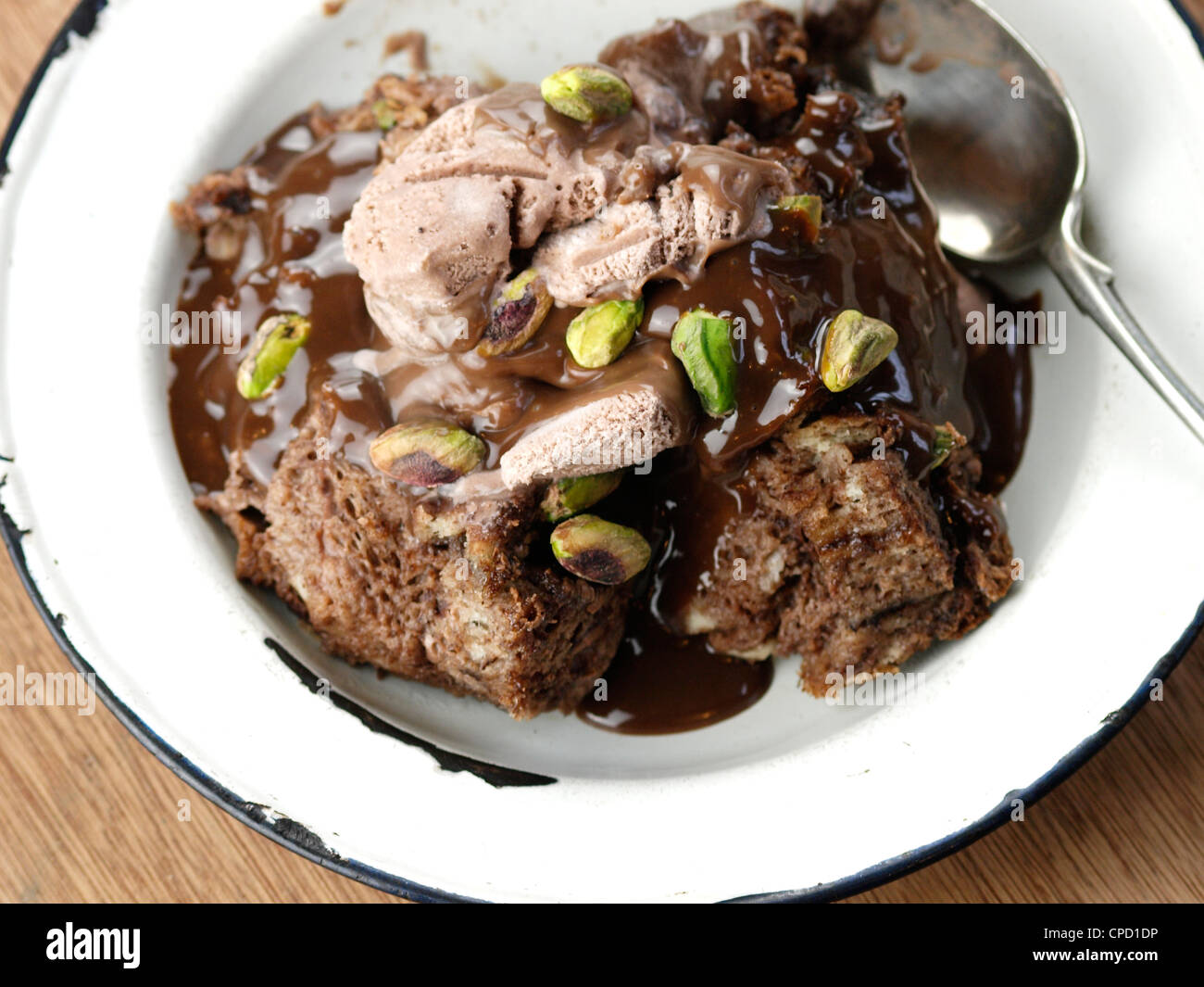 Chocolate bread and butter pudding with Chocolate Icecream, Chocolate Sauce and Pistachio Nuts Stock Photo