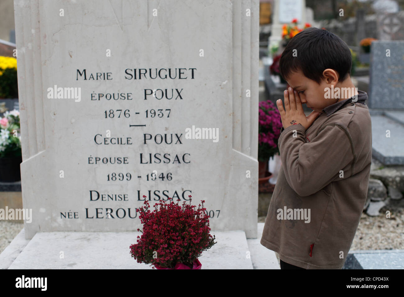Girl putting flowers on her grandmother's grave, Our, Doubs, France, Europe Stock Photo