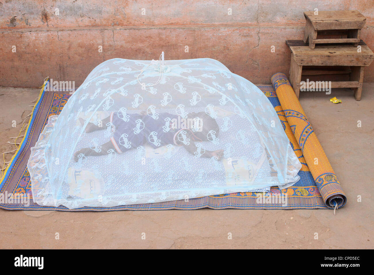 Baby sleeping under a mosquito net, Lome, Togo, West Africa, Africa Stock Photo