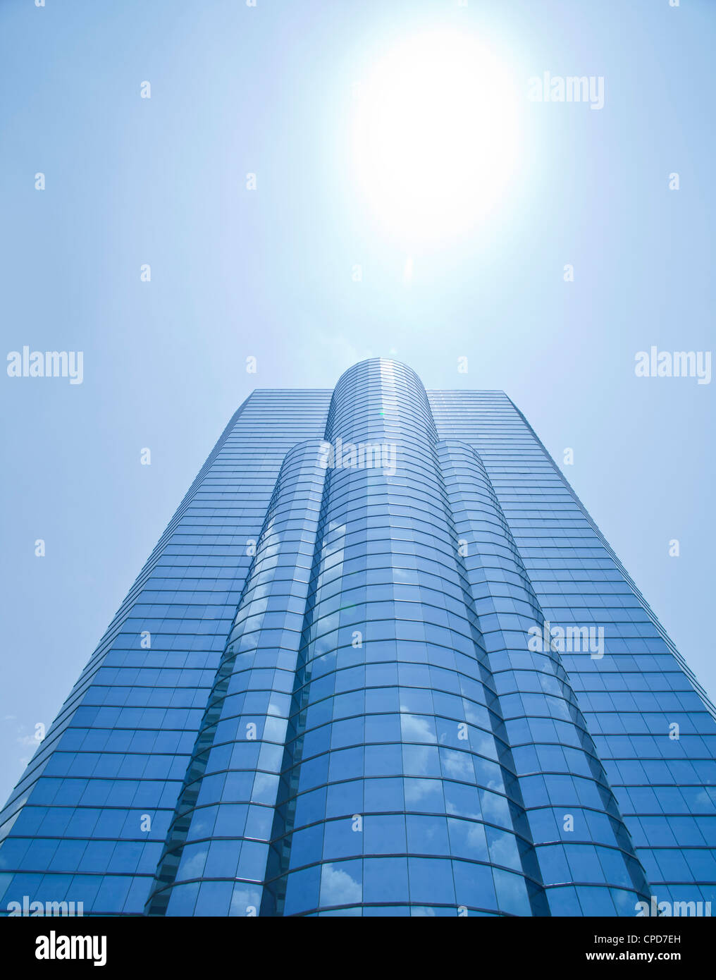 A modern glass fronted building and sun Stock Photo