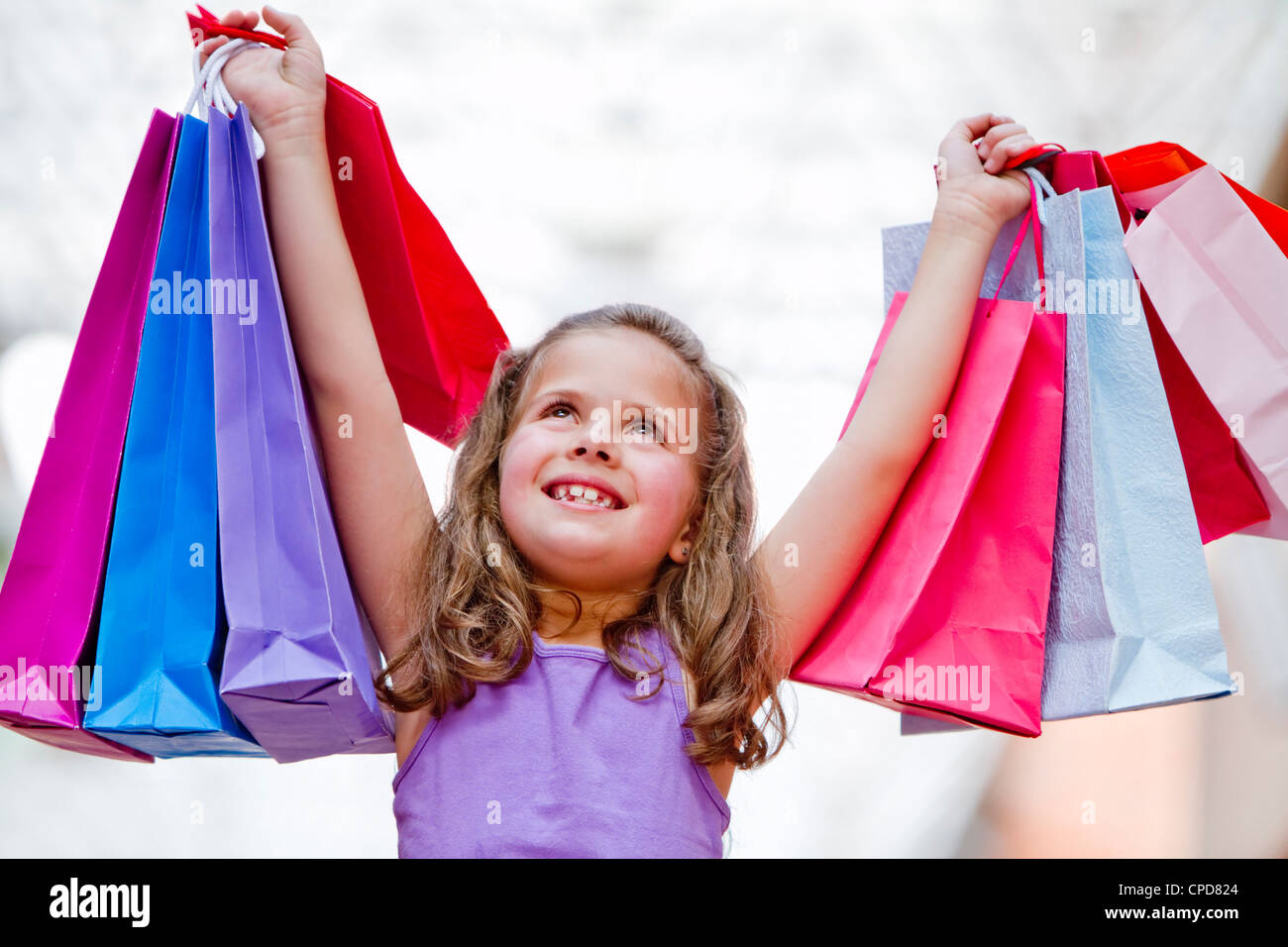 Hispanic girl lifting shopping bags Stock Photo