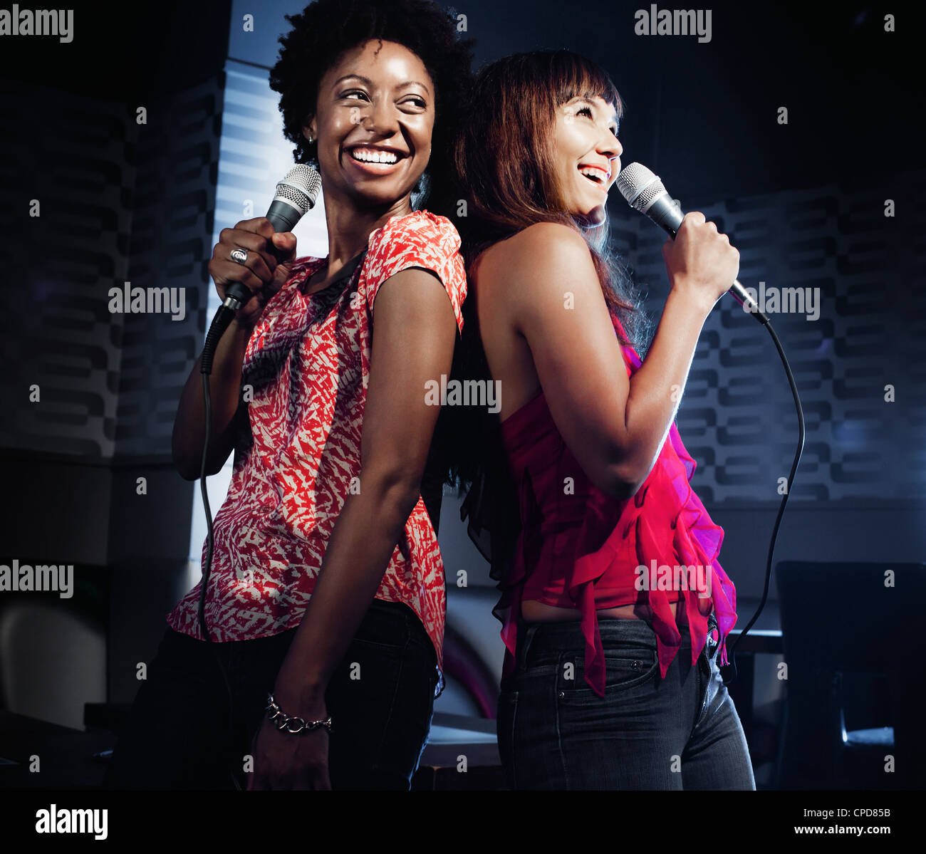 Friends singing karaoke in Stock Photo Alamy