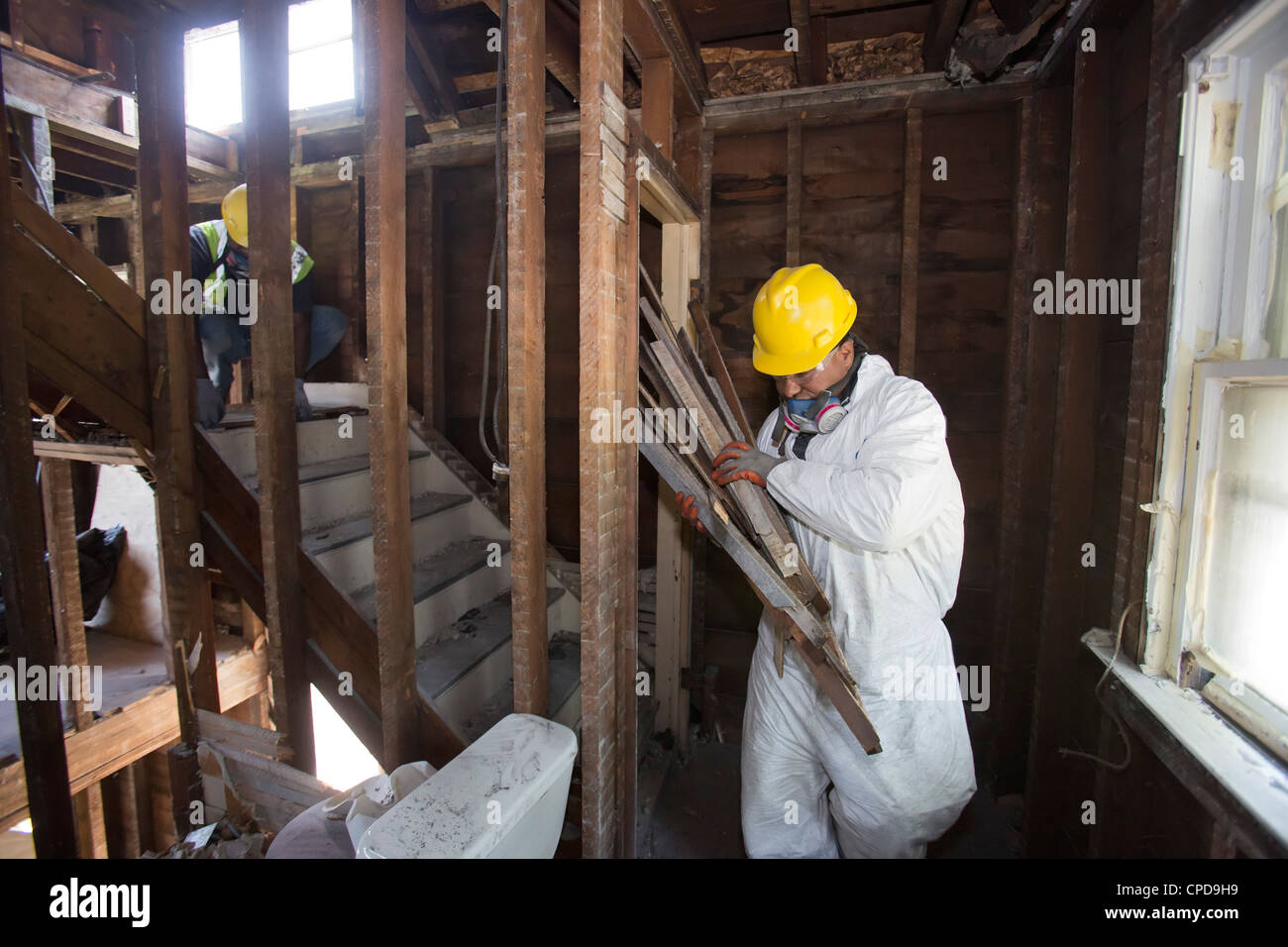 Workers salvage building materials from a home being 'deconstructed.' Stock Photo