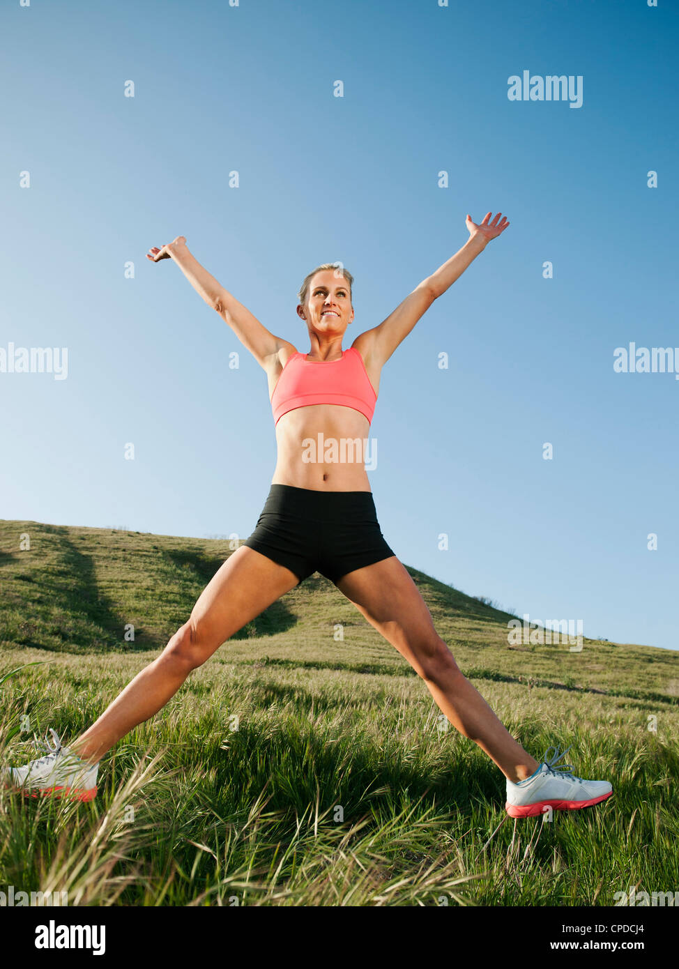 Caucasian woman in sportswear jumping in the air Stock Photo