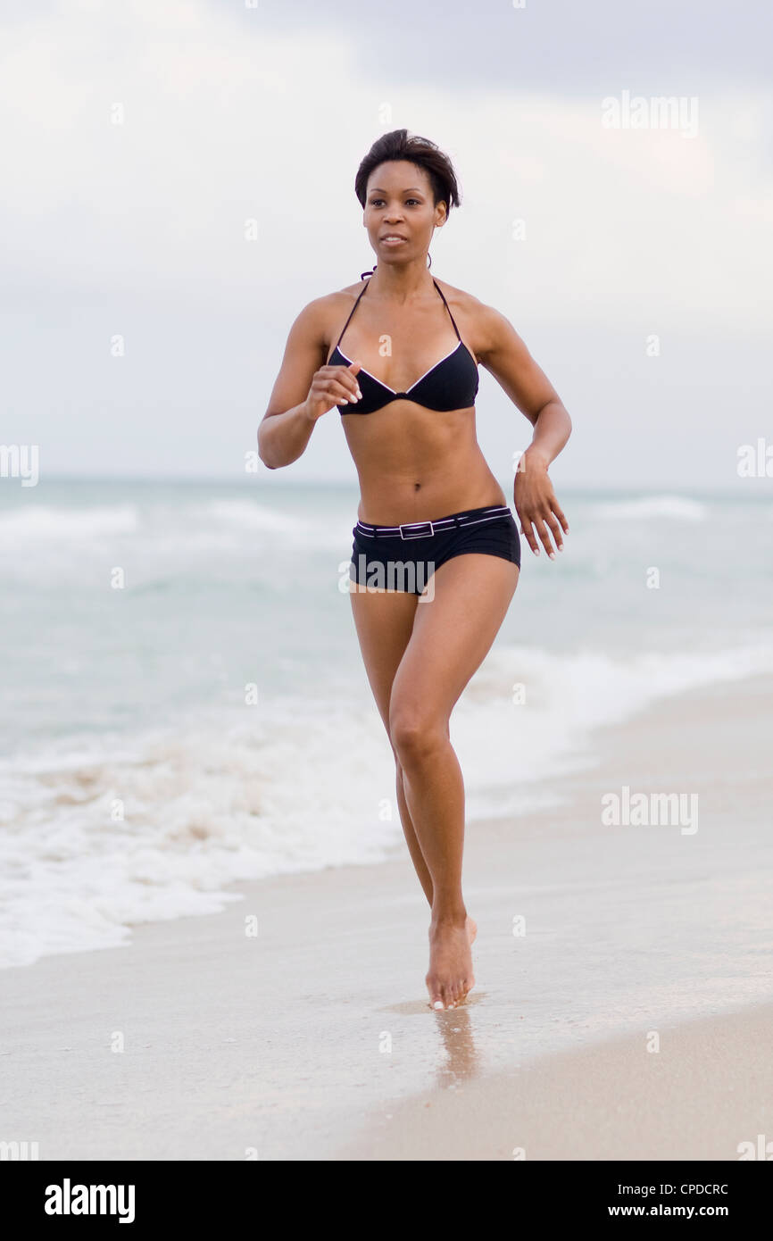 Jamaican woman in bikini running on beach Stock Photo - Alamy
