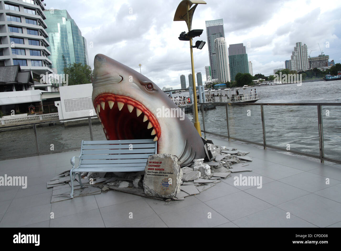 Giant white shark statue display near a bench in a shopping mall on Cha phraya river Stock Photo