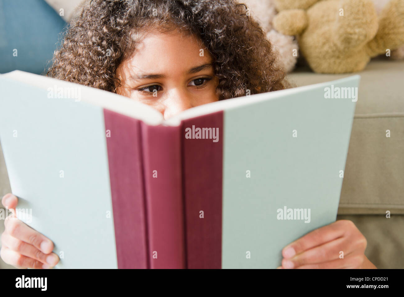 Mixed race girl reading book Stock Photo