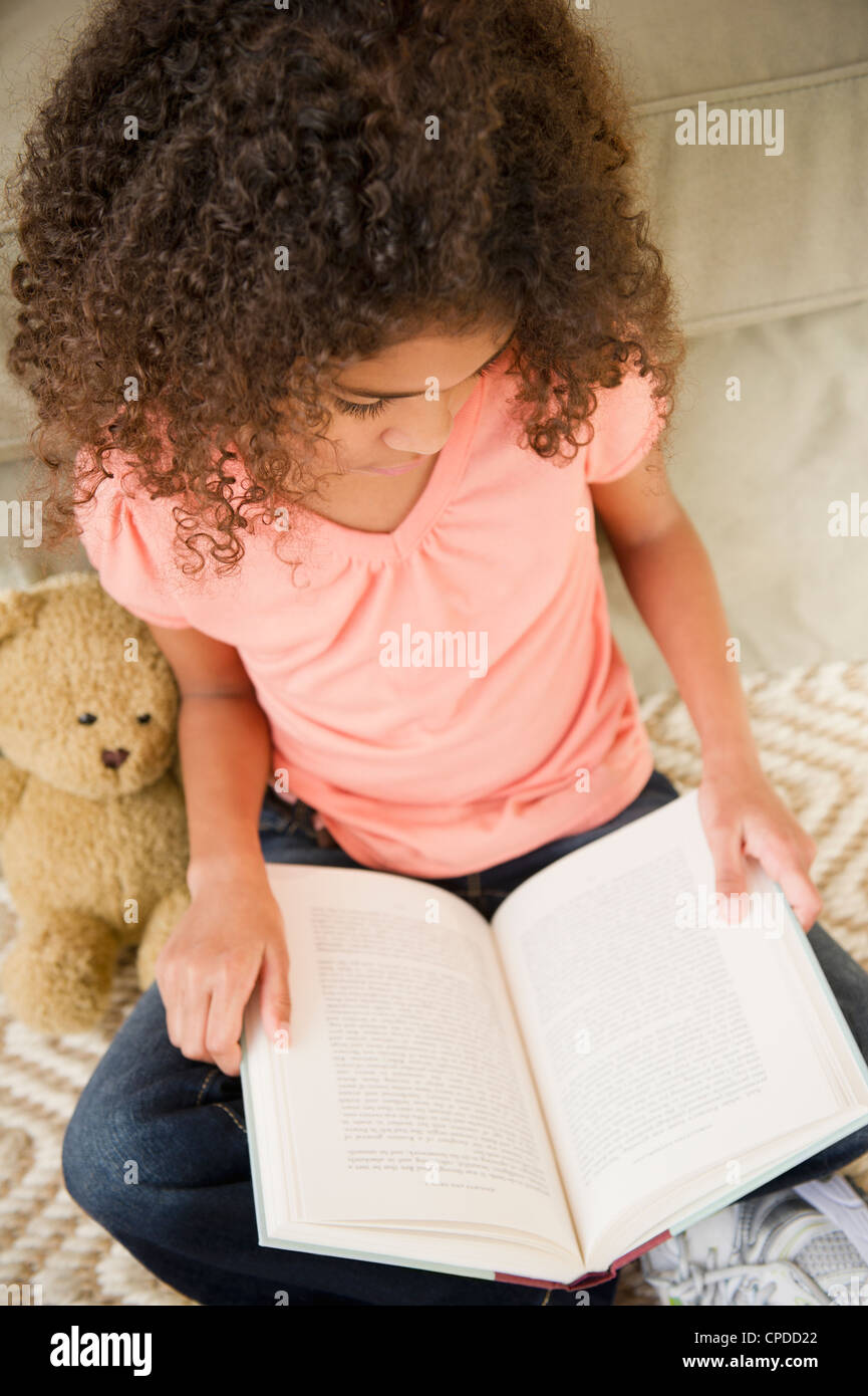Mixed race girl reading book Stock Photo