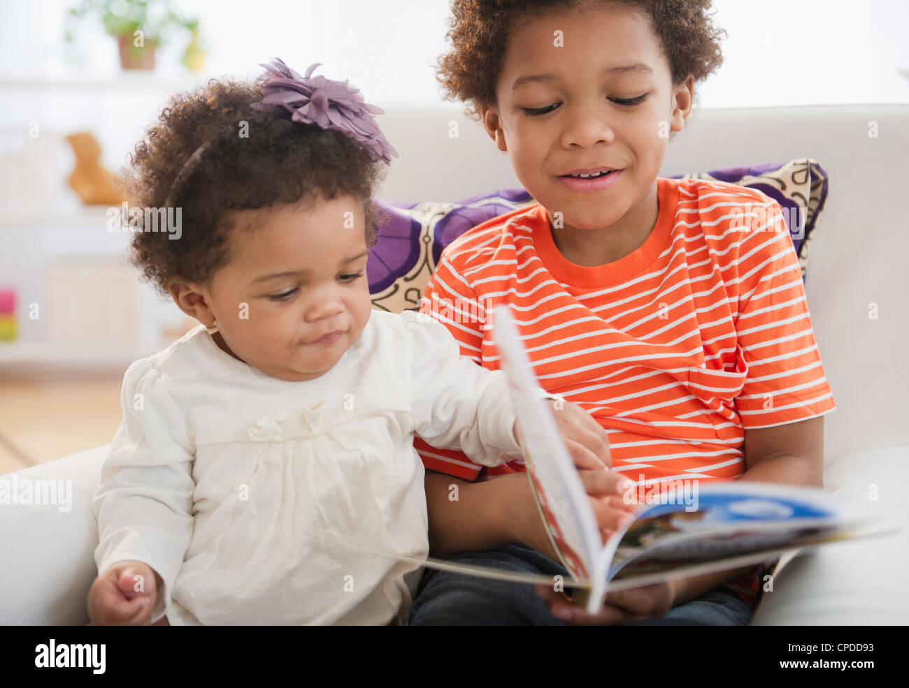 Black brother reading book to sister Stock Photo