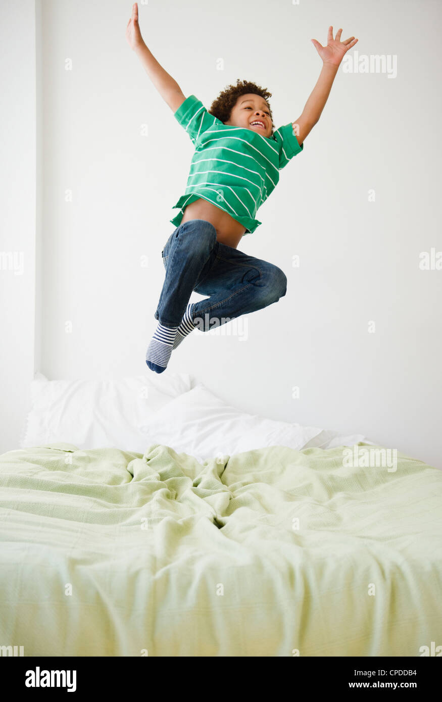 Black boy jumping on bed Stock Photo