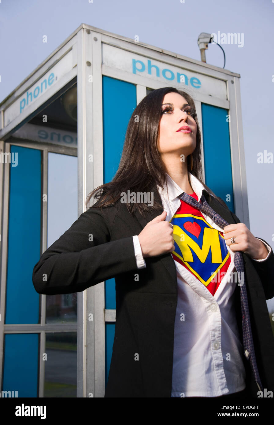 A Woman shows her Super Mother Uniform underneath her street clothes outside a phone booth Stock Photo